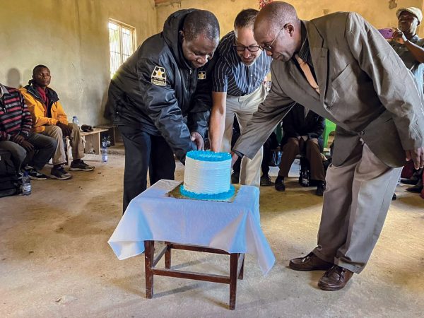 In Mozambique, two church leaders cut a cake to symbolize a renewed sense of unity and healing. At center is missionary Jeremy Smith.