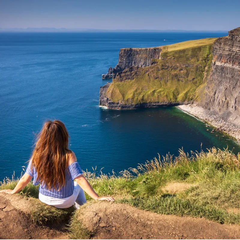 Woman Gazing At The Cliffs Of Moher In Ireland