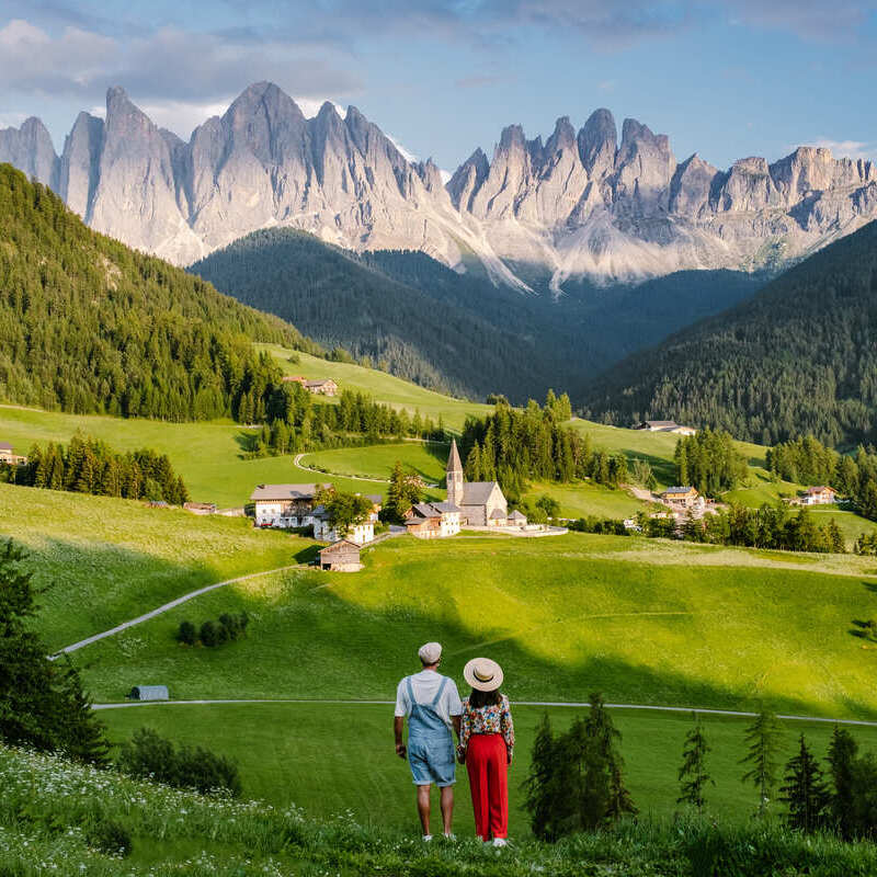 Young Woman Sat In A Viewpoint Overlooking The Dolomites In South Tyrol, Italy