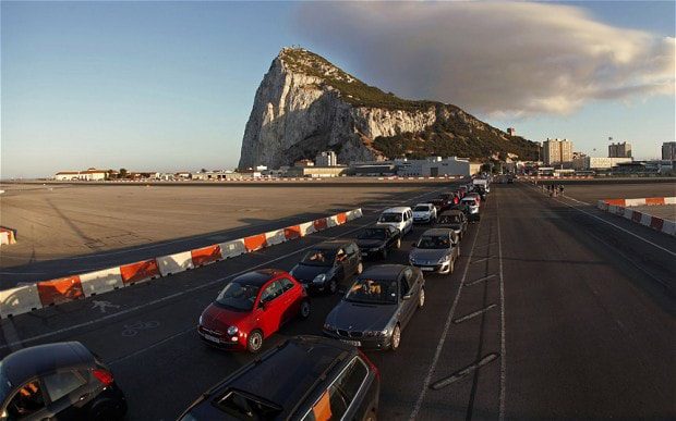 Drivers wait in line along the road of the Gibraltar International airport to enter to Spain at its border with the British territory of Gibraltar in front of the Rock (rear) in Gibraltar, south of Spain Gibraltar: Spain considers joint diplomatic offensive with Argentina over Falkland Islands