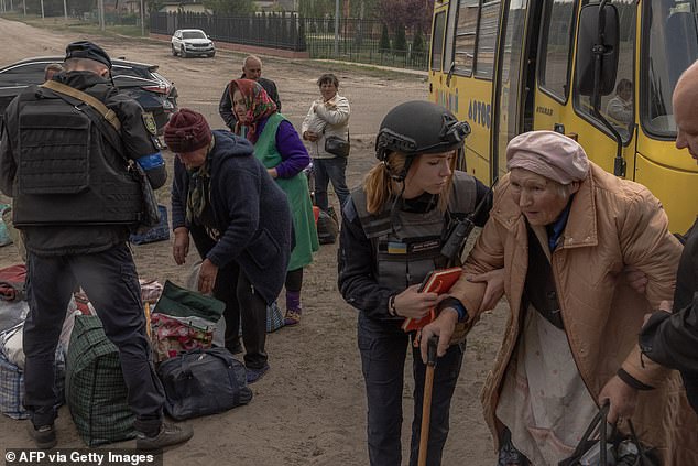 Ukrainian eacuees arrive by bus at an evacuation point in the Kharkiv region, on May 12