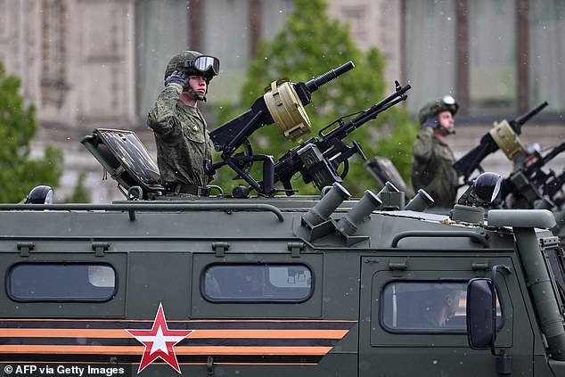 Russian troops ride atop military vehicles during the Victory Day parade in Moscow on May 9