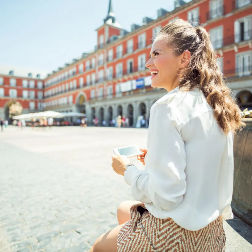 young digital nomad woman sitting in madrid spain in the sunshine