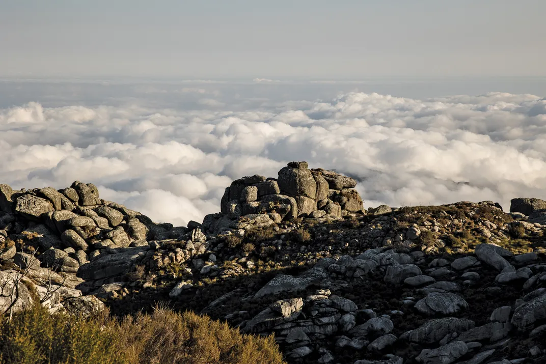 The peaks rise above thick mists and rain clouds, giving the mountain its local name—“island in the sky.”