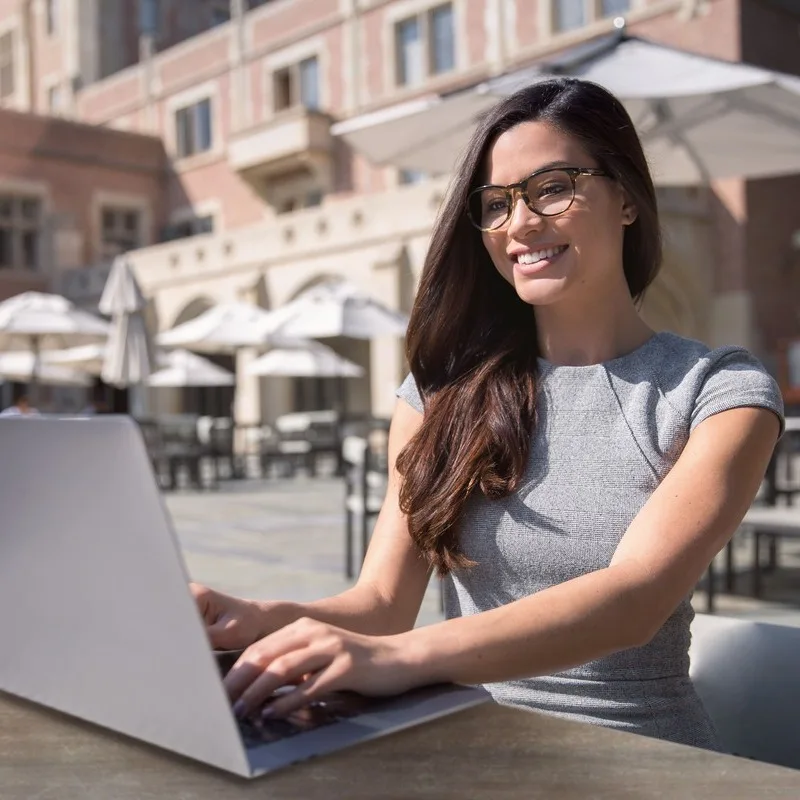 A Young Female Digital Nomad Working From Her Computer In An External Setting In Europe