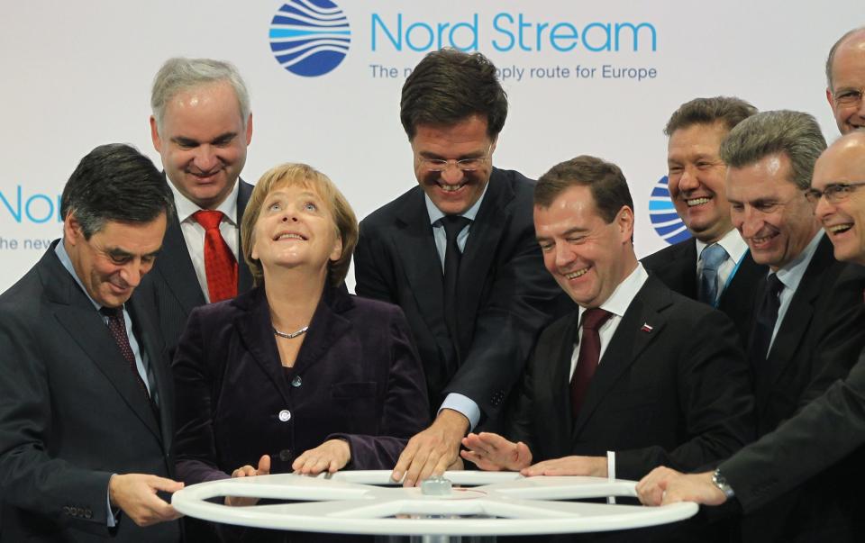 Various leaders including Angela Merkel turn a wheel to start the symbolic flow of gas through Nord Stream 1 in 2011