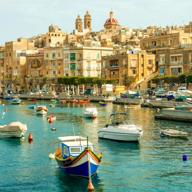 many beautiful boats in Valletta harbour with cityscape on the background, Malta