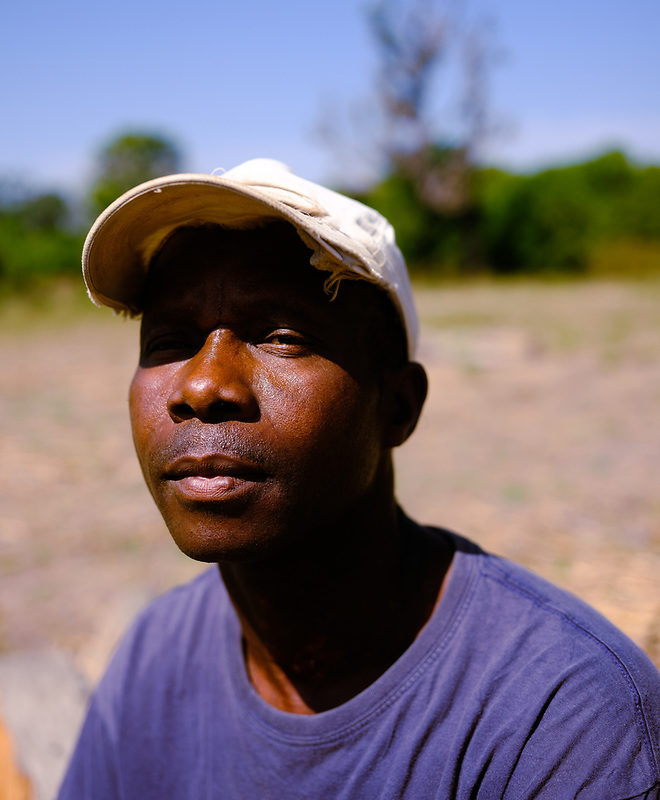 Headshot of forestry agent Malam Djassi wearing white baseball cap and blue t-shirt. Image by Ricci Shryock for Mongabay.