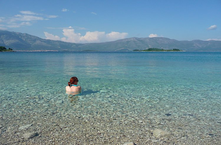 A woman enjoys the water at a beautiful, pebbly beach on the Croatian island of Korcula.