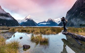 Man photographing sunset at Milford Sound, Fiordland 