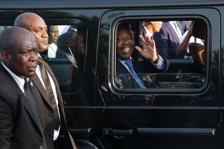 Gabonese President Ali Bongo Ondimba (R) waves from his car upon his arrival in Libreville from Morocco after treatment for a stroke, March 23, 2019.