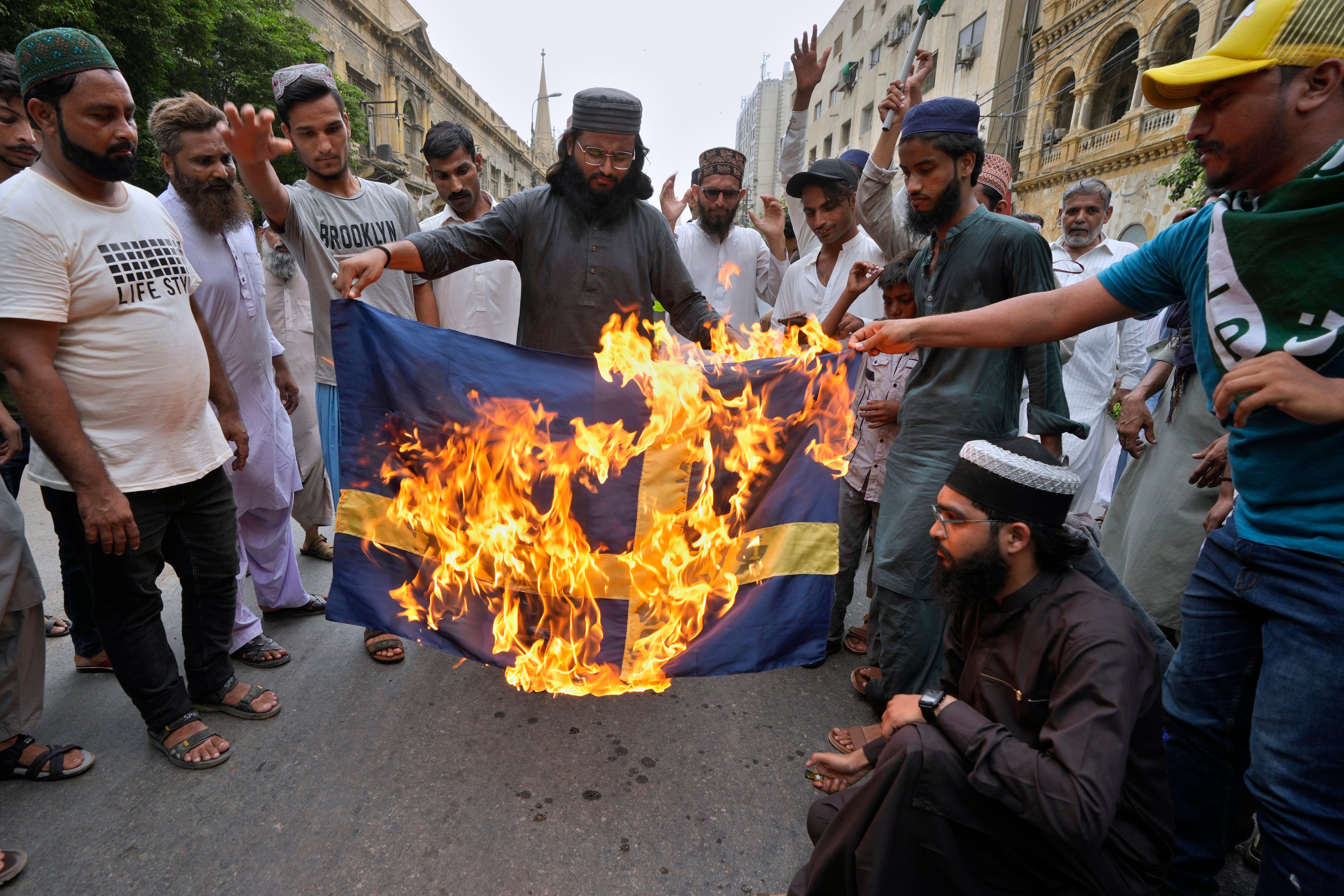 Supporters of a radical Islamist party ‘Tehreek-e-Labbaik Pakistan’ burn the representation of Swedish flag