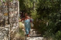 A woman walks at the village of Rovinia on the island of Corfu