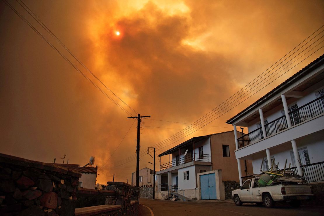 Heavy smoke covers the sky above the village of Ora in the southern slopes of the Troodos mountains, as a giant fire rages on the Mediterranean island of Cyprus, on July 3.