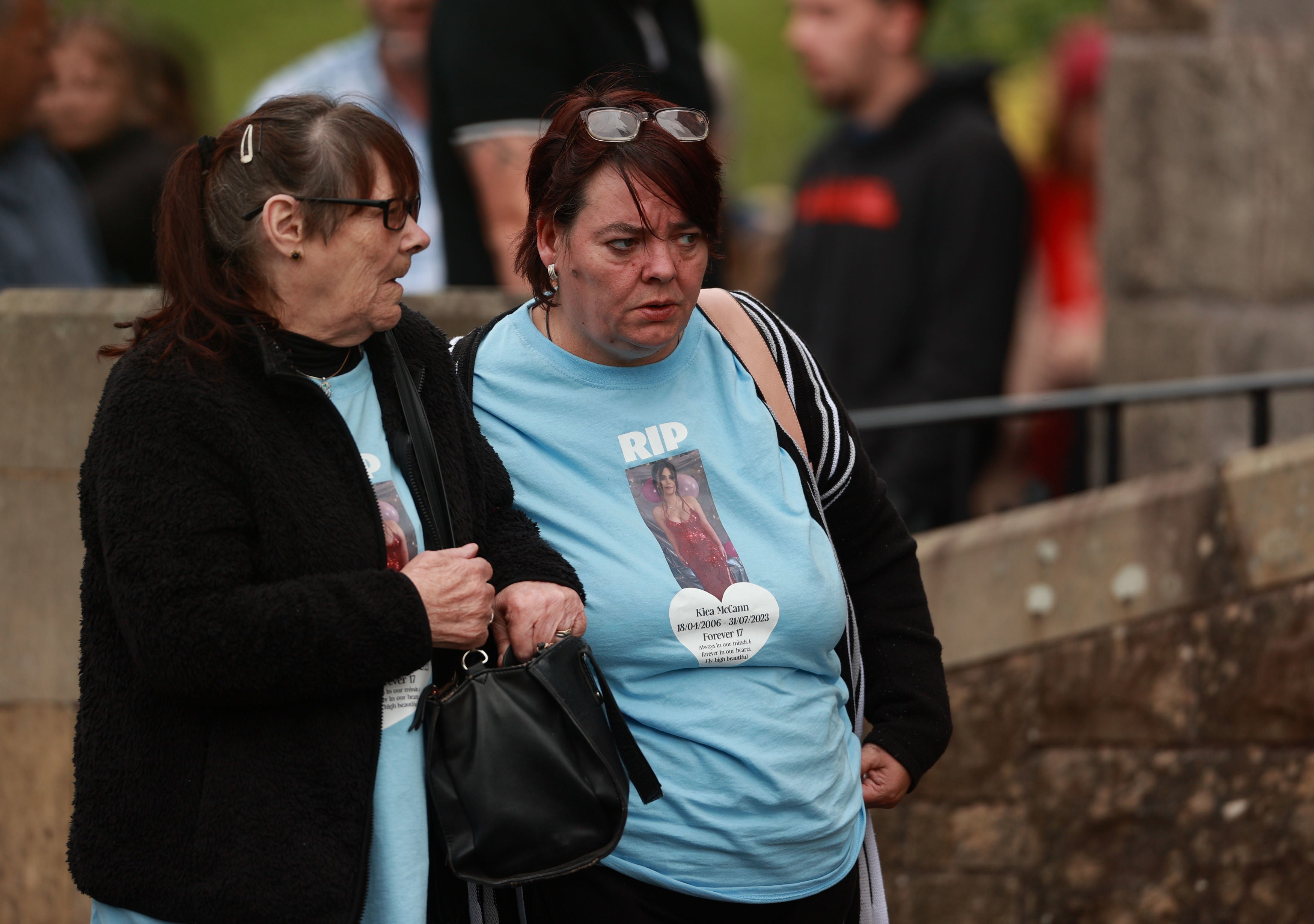 People wear T-shirts with a message and an image of Kiea McCann outside the Sacred Heart Chapel in Clones, Co. Monaghan for her funeral