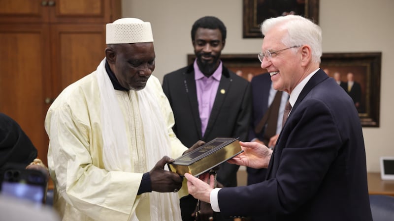 Elder D. Todd Christofferson of the Twelve Apostles presents a French copy of the Book of Mormon to gift to Sheikh Chérif Ousmane Madani Haïdara of Mali.