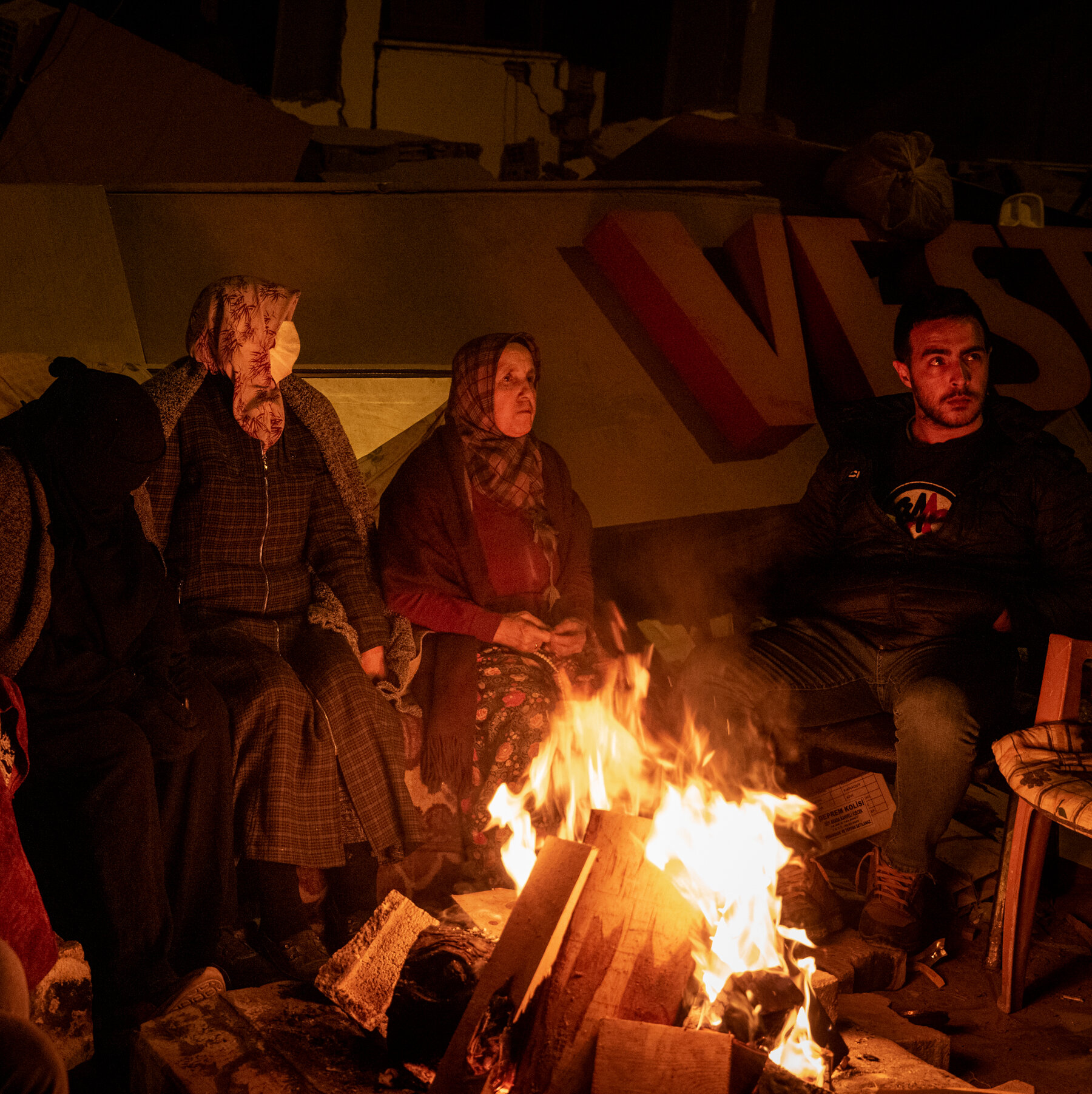 Six people sitting around a fire.