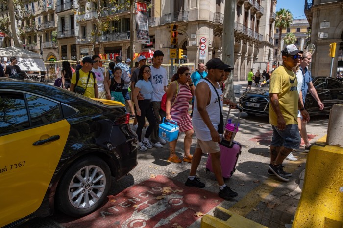 Pedestrians cross a street in Barcelona